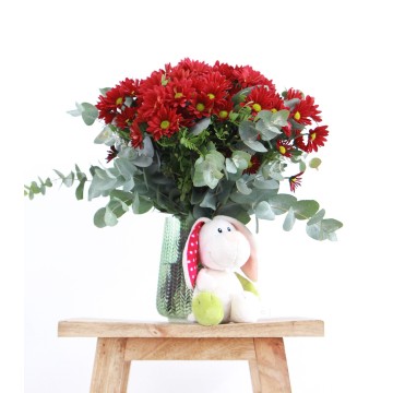 Red daisies with teddy bear